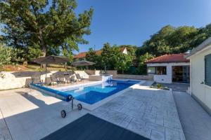 a swimming pool with a slide next to a house at Villa Idylee in Drniš