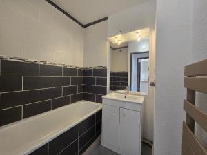 a bathroom with a bath tub and a sink and a bath tub at Appartement dans résidence avec piscine in Agde