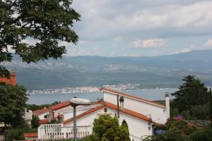 a white building with a view of the water and mountains at Appartman Tia in Polje
