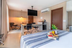 a hotel room with a bed with a table with fruit on it at Hplus Premium Palmas in Palmas +43 photos