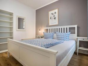 BuchholzFerienwohnung in der Mecklenburger Seenplatte的卧室里有一张白色的大床，配有蓝色的枕头