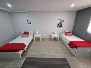two beds in a room with red and white pillows at Casa Pirosa in Aveiro