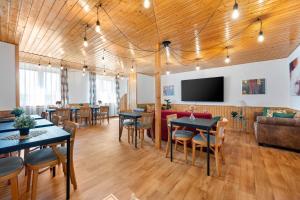 a dining room with tables and chairs and a flat screen tv at Vila Familia Valtice in Valtice