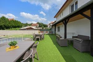a patio with tables and chairs and grass at VILA FAMELIA VALTICE Adults Only in Valtice +52 photos