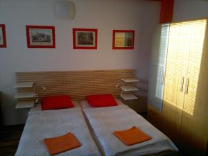 ein Schlafzimmer mit einem Bett mit roten Kissen und Büchern in der Unterkunft Red Apartment in Bratislava