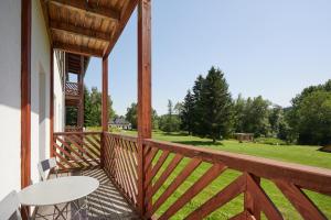 a balcony with a table and a view of a field at Resort Pasečná in Přední Výtoň