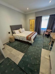 a bedroom with a bed and a table and a desk at Fraser Retreat in Howick