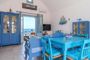 a living room with a blue table and chairs at Blue Eyes Beach Villas in Monolithos