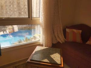 Cette chambre dispose d'une fenêtre offrant une vue sur la piscine. dans l'établissement Aqua View Resort studio, North Coast, منتجع اكوا فيو الساحل الشمالي, à El Qasaba esh Sharqīya