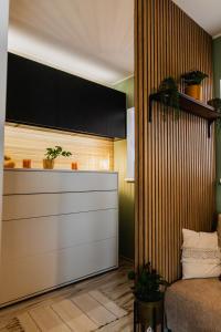 a room with a bed and a kitchen with plants at Mikroklimat in Nowa Ruda
