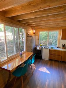 a kitchen with a table and chairs in a cabin at Cabañita Del Árbol Concón in Nevados de Chillan