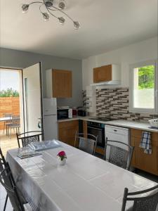 a kitchen with a table with a white tablecloth on it at Gîtes de Chaum in Chaum