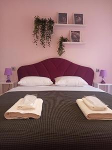 una camera da letto con un letto grande con asciugamani sopra di Athonos Secret Diamond a Salonicco Altre 29 foto