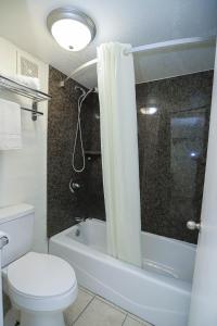 a bathroom with a toilet and a shower curtain at Express Inn in Durant
