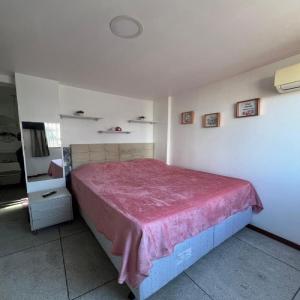 a bedroom with a bed with a pink blanket on it at STUDIO 205 | WIFI 600MB | RESIDENCIAL JC, um lugar para ficar. in Belém