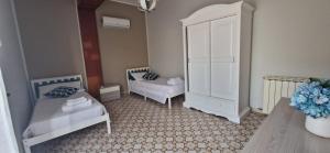 - une chambre avec 2 lits et une armoire blanche dans l'établissement La terrazza sulle Eolie, à Capo dʼOrlando