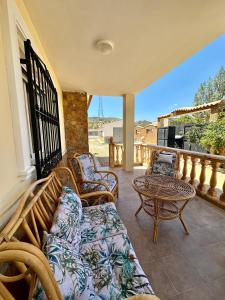 a porch with chairs and a table on a balcony at Casa Rural El Pomelo in Zurgena
