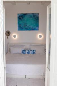 een slaapkamer met een bed met daarboven een schilderij bij Stylish Cycladic Family Villa with Private Gardens - Villa Botanica in Kampos Paros +50 foto's