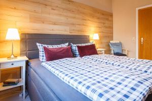 バート・ハルツブルクにあるHIRSCH Apartment Gartenschläfer - zentral - Gartenのベッドルーム1室(青と白のチェック毛布付きのベッド1台付)