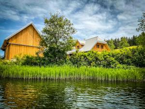 a wooden cabin next to a body of water at Chalet Hubertussee in Mariazell