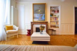 a living room with a fireplace and a table at Paris Pantin Prestige in Pantin
