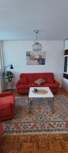 a living room with a red couch and a coffee table at Apartment Mia in Sarajevo