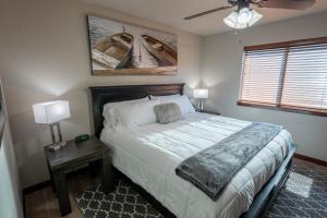 a bedroom with a bed and a table with two lamps at Fun House #265 w Water Park & Golf Cart in Arnolds Park