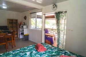 a bedroom with a bed and a table and a window at Kinakamo Lodge et Activités Rangiroa in Tiputa +165 photos