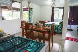 a kitchen and dining room with a table and chairs at Kinakamo Lodge et Activités Rangiroa in Tiputa