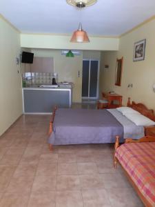 a bedroom with two beds and a kitchen at Stroubis Studios I in Megás Limniónas