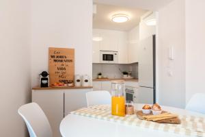 a kitchen with a table with a glass of orange juice at Apartamento Rincón Playa Carril in Vilagarcia de Arousa