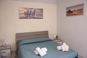 a bedroom with a bed with two white towels at Spiaggia LazzarettoHouse in Alghero
