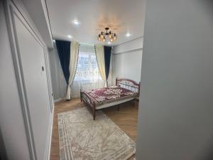 a bedroom with a bed and a window at Квартира in Atyraū