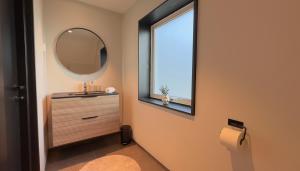 a bathroom with a mirror and a sink and a window at Reine Superior Panorama House in Reine +38 photos