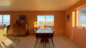 a dining room with a table and some windows at Reine Superior Panorama House in Reine