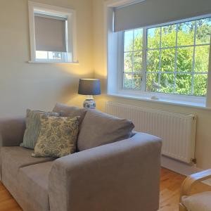 a living room with a couch and two windows at Panorama House - 400m from Sandbanks beach in Sandbanks