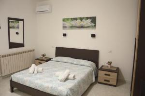 a bedroom with a bed with two night stands and two tables at Spiaggia LazzarettoHouse in Alghero