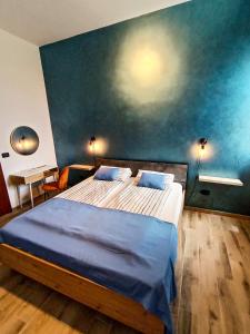 a bedroom with a large bed with a blue wall at Mistral Guesthouse in Castro di Lecce