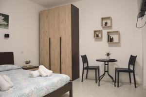 a bedroom with a bed and a table and chairs at Spiaggia LazzarettoHouse in Alghero