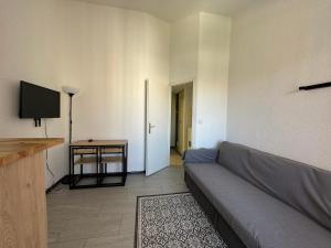 a living room with a couch and a table at T1 Cap D'Agde piscine Port in Cap d'Agde +3 photos