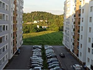 多博伊Apartman Oaza的两栋建筑之间的停车场停放的汽车的鸟瞰图