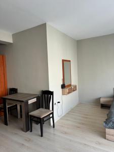 a dining room with a table and chairs and a mirror at Студио Мая in Sunny Beach