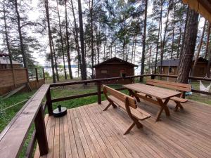 a wooden deck with a picnic table and a house at Domek z widokiem jeziora in Borsk