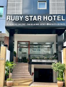 a building with a spiral staircase in front of a hotel at Ruby Star Hotel Nam Quoc Cang in Ho Chi Minh City