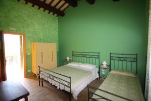 a bedroom with two beds and a green wall at Agriturismo L'Arcadia in Citta' Sant'Angelo