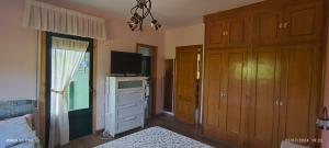 a bedroom with a bed and a tv and a dresser at Casa Mercedes in Quiroga +3 photos