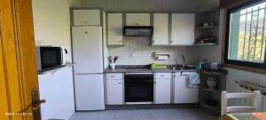 a kitchen with white appliances and a white refrigerator at Casa Mercedes in Quiroga