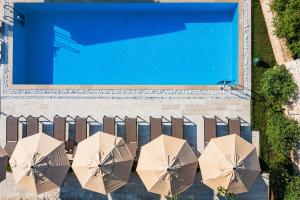 an overhead view of umbrellas next to a swimming pool at Boutique hotel Ruzmarin SPA & Garden by Aycon in Budva