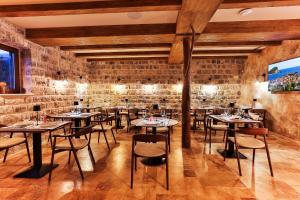a restaurant with tables and chairs in a brick wall at Boutique hotel Ruzmarin SPA & Garden by Aycon in Budva