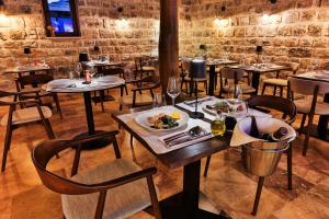 a restaurant with tables and chairs with a plate of food at Boutique hotel Ruzmarin SPA & Garden by Aycon in Budva